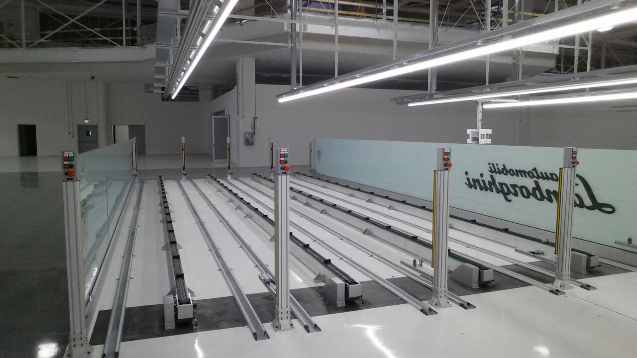 Struttura di movimentazione su rotaie Lamborghini, con moduli di controllo e barriere di sicurezza integrate per garantire precisione e affidabilità.