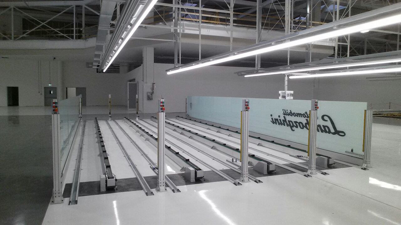 Struttura di movimentazione su rotaie Lamborghini, con moduli di controllo e barriere di sicurezza integrate per garantire precisione e affidabilità.