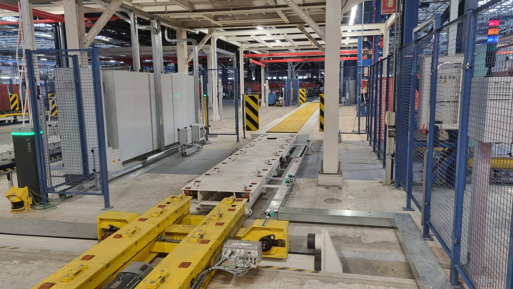 Sistema di trasporto automatico con piattaforma mobile e guide integrate, progettato per ottimizzare il flusso di produzione.