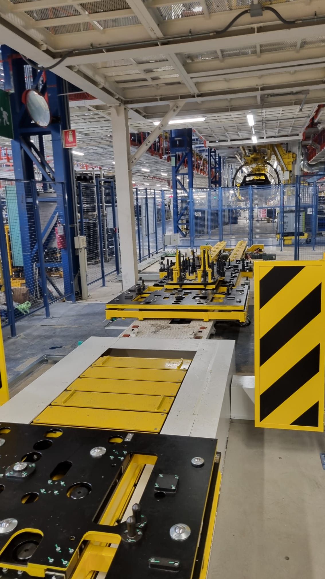 Linea di produzione con convogliatore automatico giallo, integrato in un sistema di movimentazione industriale.