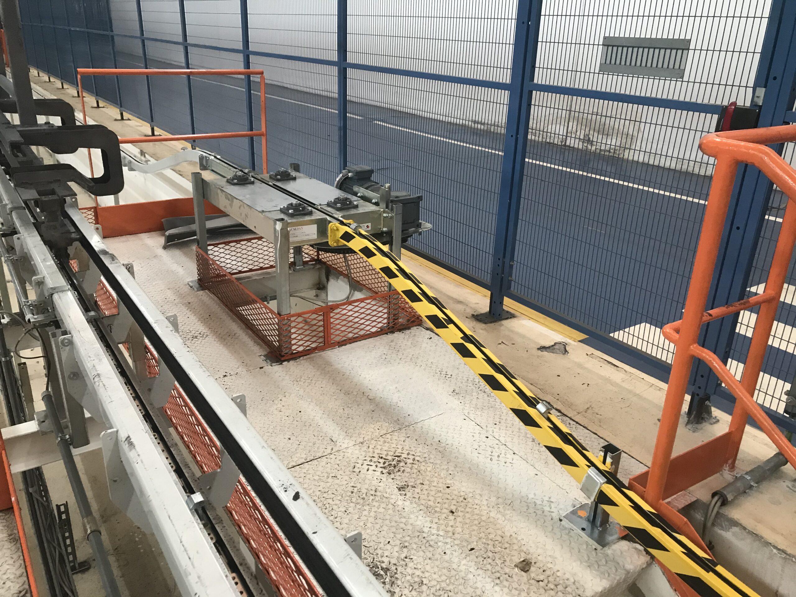 Dettaglio di un impianto con rotaia e barriera di sicurezza giallo-nera.